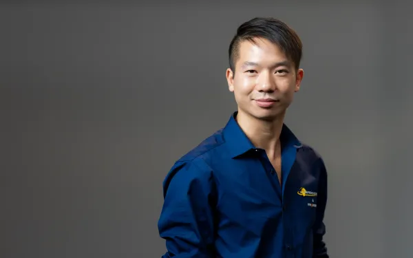 Chinese trainer Benjamin Yu in a blue shirt in the photo studio